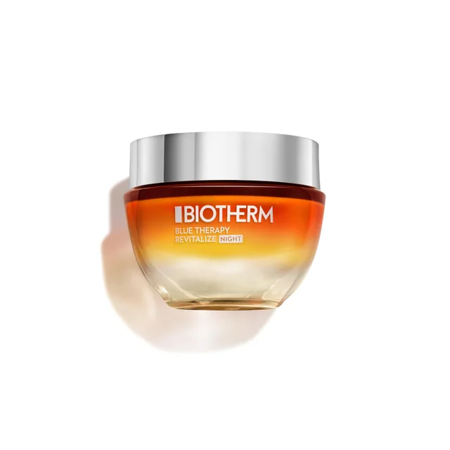 A jar of Biotherm Blue Therapy Revitalize Anti-Aging Night Cream, featuring a gradient amber-to-clear glass container with a silver lid, centered against a plain white background.